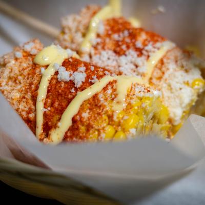 Elote topped with mayonnaise, chili powder, and cotija cheese.