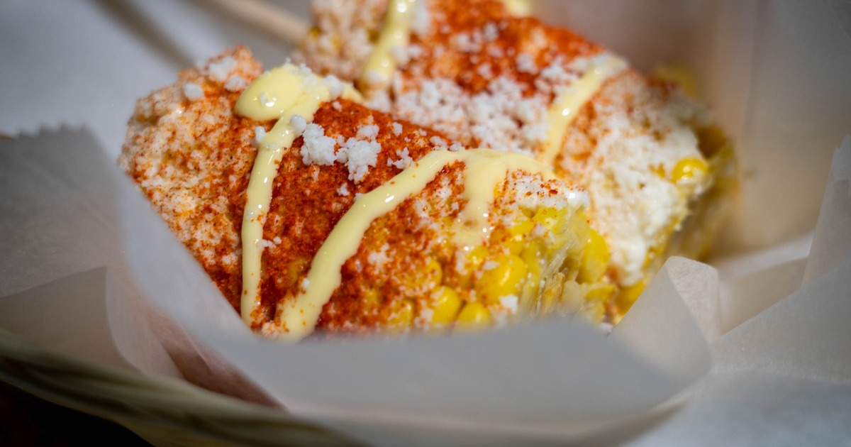 Mexican street corn topped with chili powder, cheese and sauce