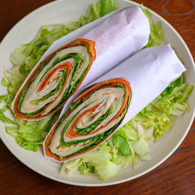Buffalo Turkey Wrap  sliced in half and served on a bed of lettuce.