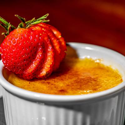 Creme Brulee topped with sliced strawberry.