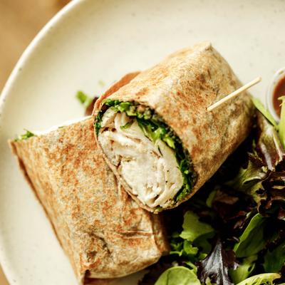 Wrap halves with mixed greens on a round plate.
