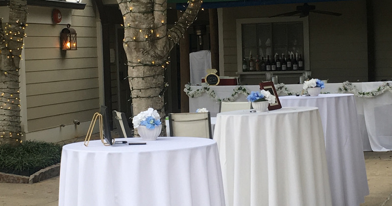 Exterior, white skirted tables decorated for a celebration