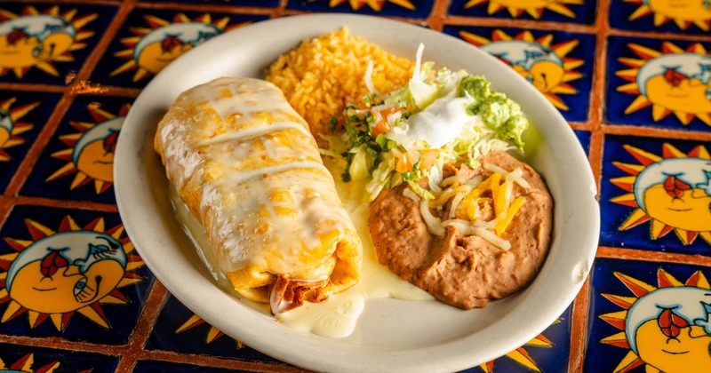 Fajita chimichanga served with refried beans, rice and a salad