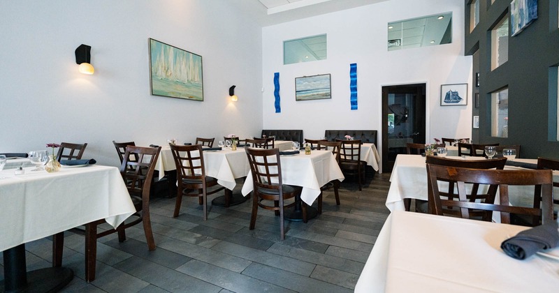 Interior, dining area, tables for two and four, tile flooring, framed paintings on the walls