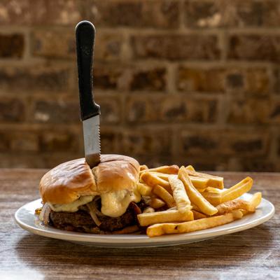 Cheeseburger with fries on a wooden table.