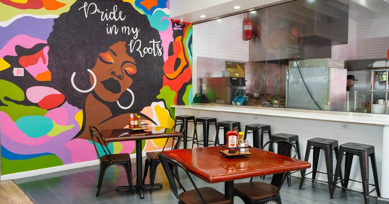 Interior with colorful mural of a woman with an afro, tables with condiments