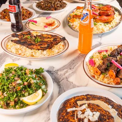 Various dishes and sodas on a table.