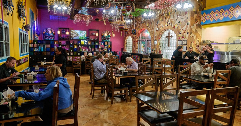 Restaurant's interior with people seating at tables