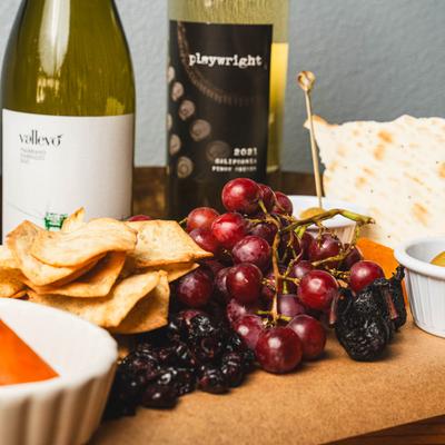 Hot Blooded Signature Charcuterie and white wine bottles, close up.