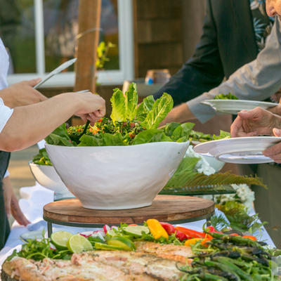 Eployee pouring salad for guests