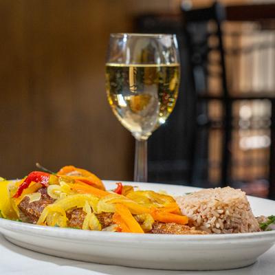Fried fish with grilled veggies, rice, and a glass of white wine.