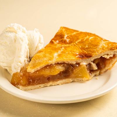 A slice of apple pie served with a scoop of vanilla ice cream.