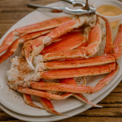 Snow crab legs served with a dipping sauce.