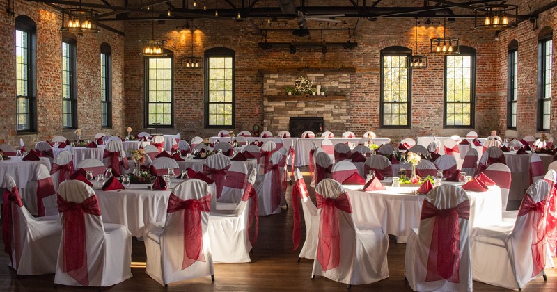 Interior, banquette area, high ceiling, round tables for eight, vintage brick walls