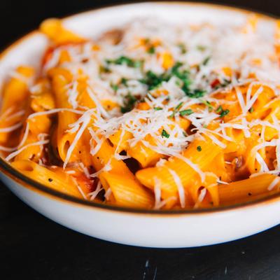 Rigatoni pasta with vodka sauce, mushrooms, sweet pepper, tomato, and shredded cheese.