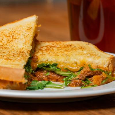 Sandwiches with chicken, pesto, tomatoes, and cheese.