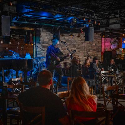 A guitarist performing for audience.