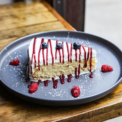 Mexican traditional sponge cake with mixed berries, berry sauce, and powdered sugar.