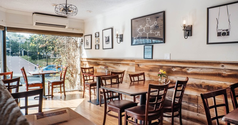 Interior, wooden tables and chairs, poster and photographs as decoration on the walls
