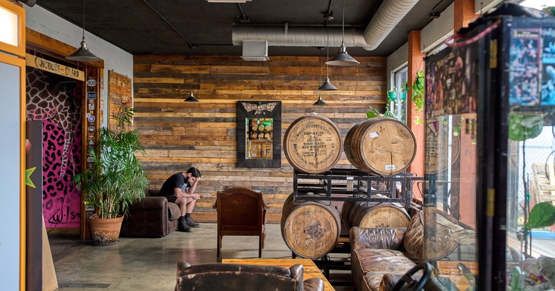 Lounge area with wood panels, whiskey barrels and leather chairs
