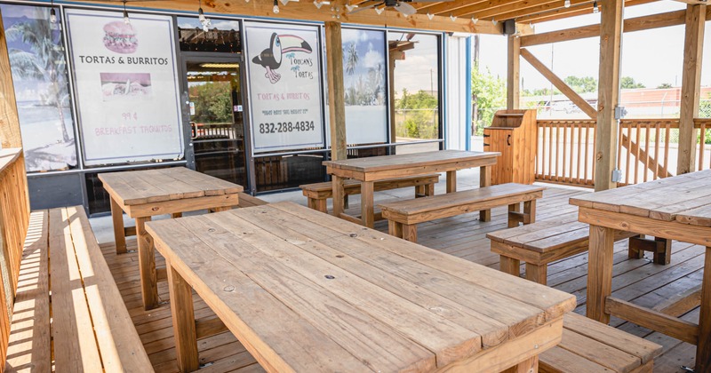 Exterior, covered wooden patio tables and seating