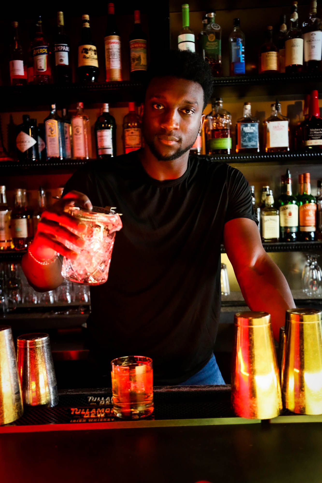 Bartender looking at the camera while serving a drink photo
