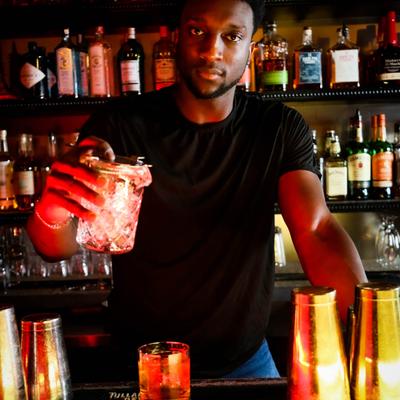 Bartender looking at the camera while serving a drink.