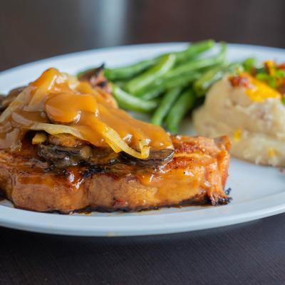 Roast pork with gravy, mashed potatoes and green beans.