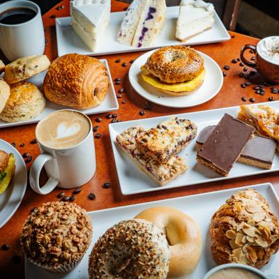 Variety of with pastries, sandwiches and cakes served alongsdie hot drinks.