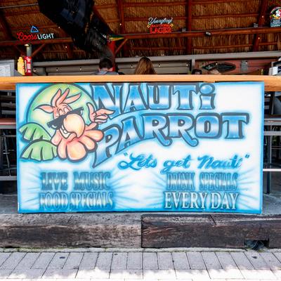 Colorful Nauti Parrot bar sign promoting live music and daily drink specials.