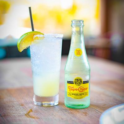Ranch Water cocktail with a bottle of carbonated mineral water next to it.