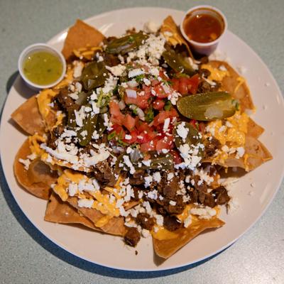 Carne Asada Nachos loaded with steak, melted cheese, and fresh pico de gallo.