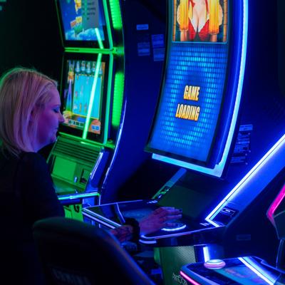 Person at a slot machine with blue lighting.