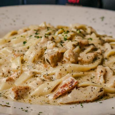 Creamy fettucine Alfredo pasta with chicken and herbs.