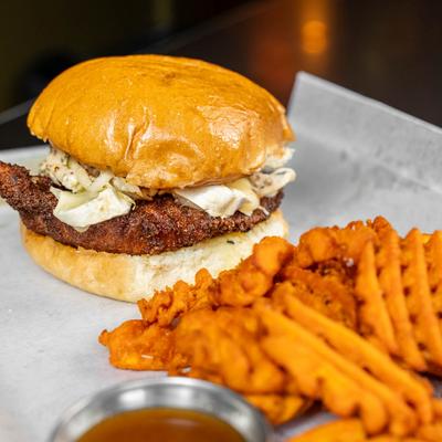 Schnitzel Burger with waffle fries and sauce.