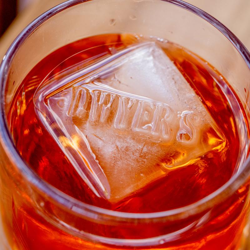 Ice cube with sign in Old Fashoned cocktail glass.
