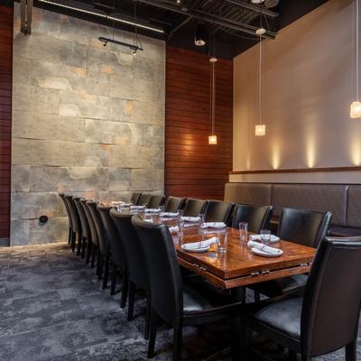 Elegant dining room with a set table, pendant lights, and eclectic walls.