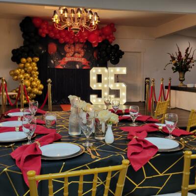Birthday setup with balloons, flowers, and an illuminated number display.