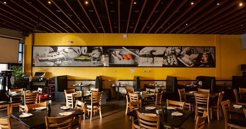 Interior, dining area, wooden top tables for four, seating booths in the back, warm atmosphere