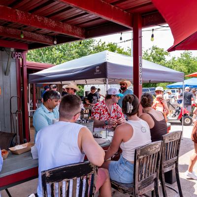 People enjoying food and drinks at an outdoor table.