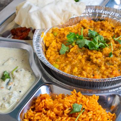 A platter with a lentil dish and sides.