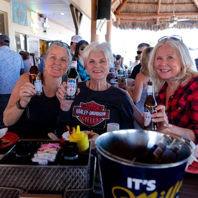 People smiling and holding drinks.