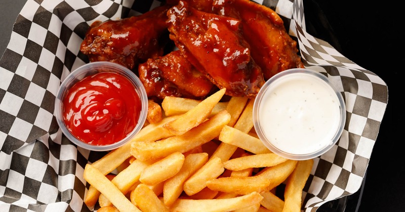 BBQ wings with fries ketchup and a sauce, top view