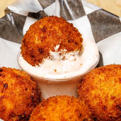 Homemade tater tots served with a dipping sauce, close-up.