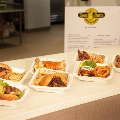 Variety of meals with sides in takeout containers served on a counter.