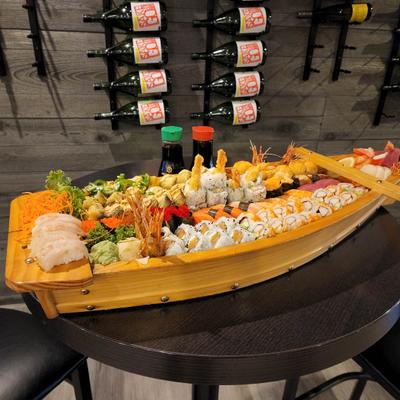 Large sushi boat filled with a variety of sushi, sashimi, and rolls.