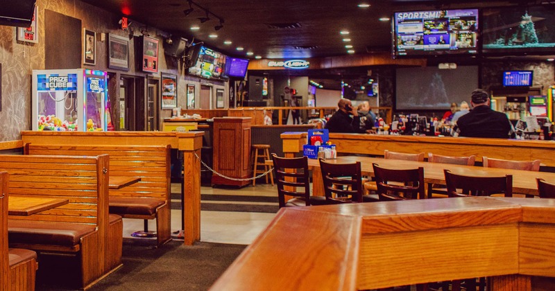 Interior, wooden, wide view, tv and framed pictures on the wall, bar in the background