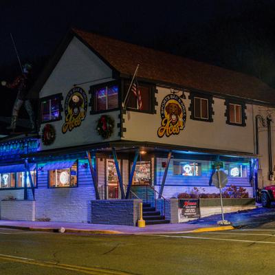 Aces Sports Bar and Grill exterior with blue lights and holiday decor.