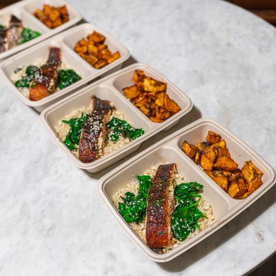 Several Asian salmon meals on trays.