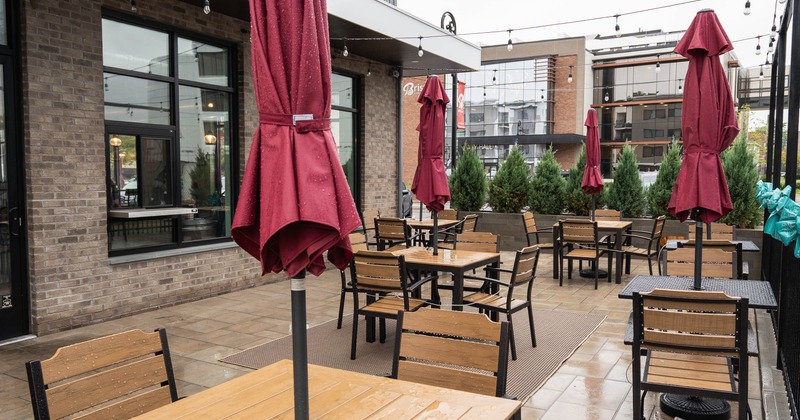 Exterior, patio with wooden tables, closed red umbrellas